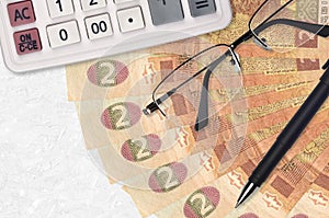 2 Ukrainian hryvnias bills fan and calculator with glasses and pen. Business loan or tax payment season concept