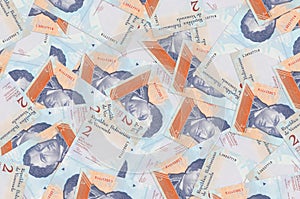 2 Venezuelian bolivar bills lies in big pile. Rich life conceptual background