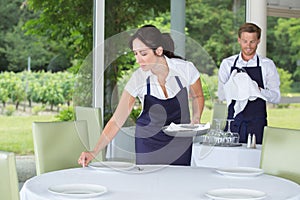 2 waiters setting table in fancy restaurant