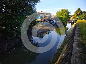 2 water boats with damaged and unmaintained conditions on the edge of the water dam