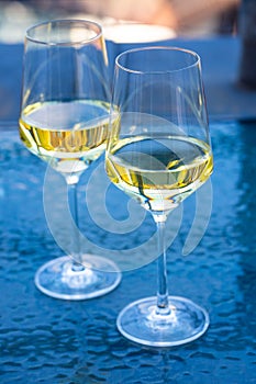 2 wine glasses on glass table with tulips