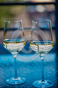 2 wine glasses on glass table with tulips