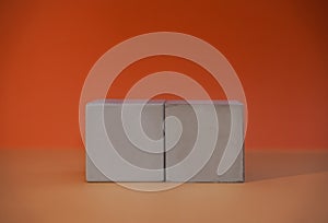 2 wood blocks isolated on orange background with copy space. Empty grey wooden cubes for your text or message. Business