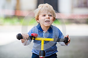 2 years old toddler riding on his first bike