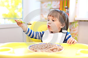 2 years toddler eating buckwheat groats