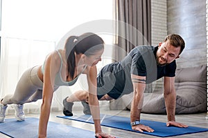 20-25 age beautiful sporty couple practicing yoga doing four-limbed staff pose at home