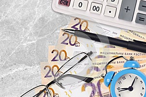 20 Belorussian rubles bills and calculator with glasses and pen. Business loan or tax payment season concept. Time to pay taxes