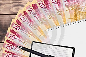 20 Belorussian rubles bills fan and notepad with contact book and black pen. Concept of financial planning and business strategy