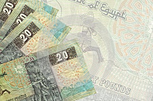 20 Egyptian pounds bills lies in stack on background of big semi-transparent banknote. Abstract business background