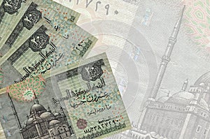 20 Egyptian pounds bills lies in stack on background of big semi-transparent banknote. Abstract business background