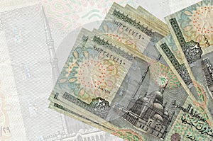 20 Egyptian pounds bills lies in stack on background of big semi-transparent banknote. Abstract presentation of national currency