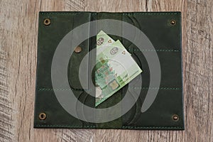 20 hryvnia in a woman`s wallet on a wooden background