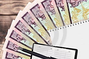 20 Sri Lankan rupees bills fan and notepad with contact book and black pen. Concept of financial planning and business strategy