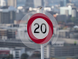 20 twenty kilometer per hour kph speed limit traffic sign in front of cityscape skyline Auckland New Zealand Aotearoa