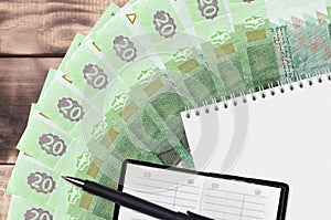 20 Ukrainian hryvnias bills fan and notepad with contact book and black pen. Concept of financial planning and business strategy