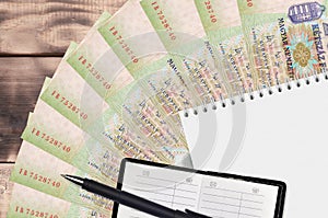 200 Hungarian forint bills fan and notepad with contact book and black pen. Concept of financial planning and business strategy