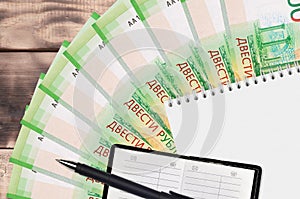 200 russian rubles bills fan and notepad with contact book and black pen. Concept of financial planning and business strategy