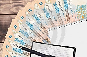 200 Ukrainian hryvnias bills fan and notepad with contact book and black pen. Concept of financial planning and business strategy