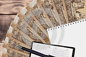 2000 Hungarian forint bills fan and notepad with contact book and black pen. Concept of financial planning and business strategy