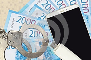 2000 russian rubles bills and smartphone with police handcuffs. Concept of hackers phishing attacks, illegal scam or malware soft
