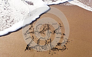2012 and 2013 written in sand with waves