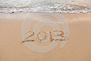 2013 written in sand with waves