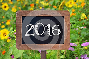 2016 written on a wooden sign, Sunflowers and wild flowers