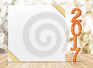 2017 New year glitter number and white card with gold ribbon in