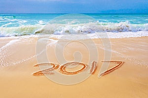 2017 written on the sand of a beach, travel new year concept