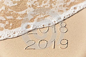 2018 2019 inscription written in the wet yellow beach sand being