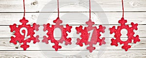 2018 cut in red fabric christmas ornaments hanging on white wooden planks background