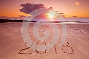 2018 inscription on wet beach sand