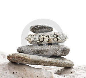2018 on pebbles stacked on driftwood