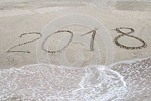 2018 written on the sand of a beach