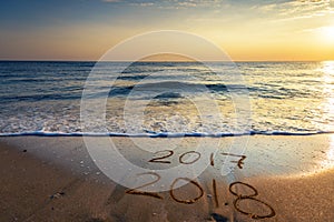 2018 written on the sand of a beach, travel 2018 new year concept.