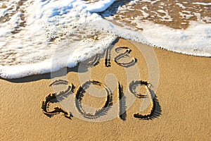 2019, 2018 years written on sandy beach sea.