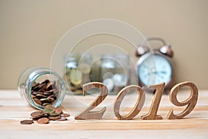 2019 Happy New Year with gold coins stack and wooden number on table. business, investment, retirement planning