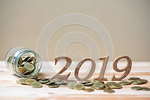 2019 Happy New Year with gold coins stack and wooden number on table. business, investment, retirement planning, finance, Saving a
