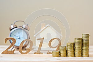 2019 Happy New Year with gold coins stack and wooden number on table. business, investment, retirement planning, finance, Saving a