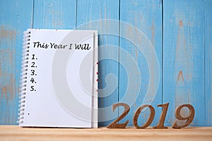 2019 Happy New years with notebook â€œ This Year I Will â€œ text and wooden number on table and copy space.