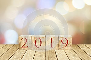 2019 new year greeting card, wooden cubes with 2019 on wood table over blur bokeh background with copy space for text, new year t