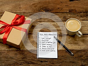 2019 New Year Resolutions written on notebook with Gift and coffee on wood table in Better life goals