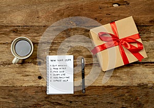 2019 New Year Resolutions written on notebook with Gift and coffee on wood table in Happy life goals