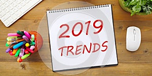 2019 trends on notebook paper at office desk, business vision co