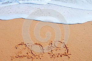 2019 YEAR inscription written in the wet yellow beach sand. Concept of celebrating the New Year, party on the shores of the