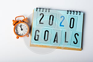 2020 Goals. New year goal, plan, action text on notepad with orange clock. Business motivation concepts ideas
