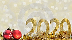 2020 golden figures in glitter and ribbon on abstract blur light background