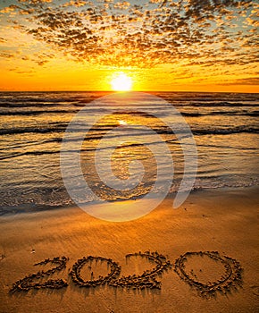 2020 inscription written on sandy beach