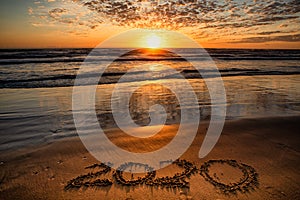 2020 inscription written on sandy beach