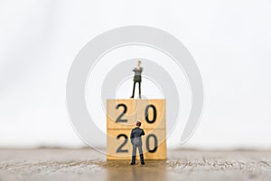 2020 new year and Business Planning concept. Close up of two businessman miniature figure standing in front of  stack of wood